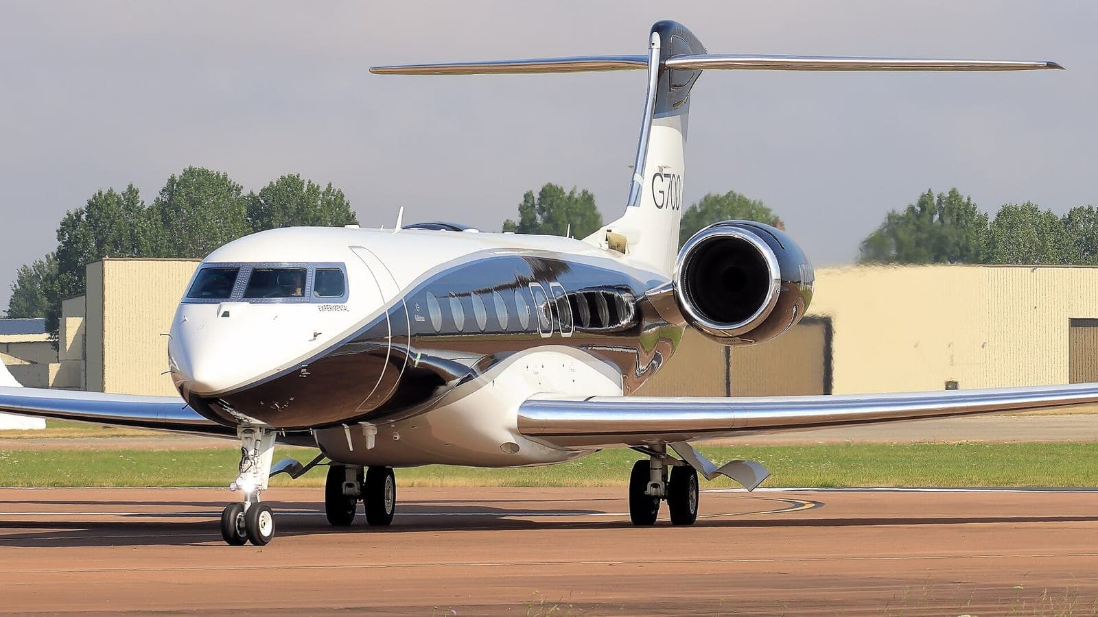 A Gulfstream G700 taxiing towards the camera in a front three-quarter view from the left, G700 painted on its tail fin and one engine nacelle filling the right of the frame.