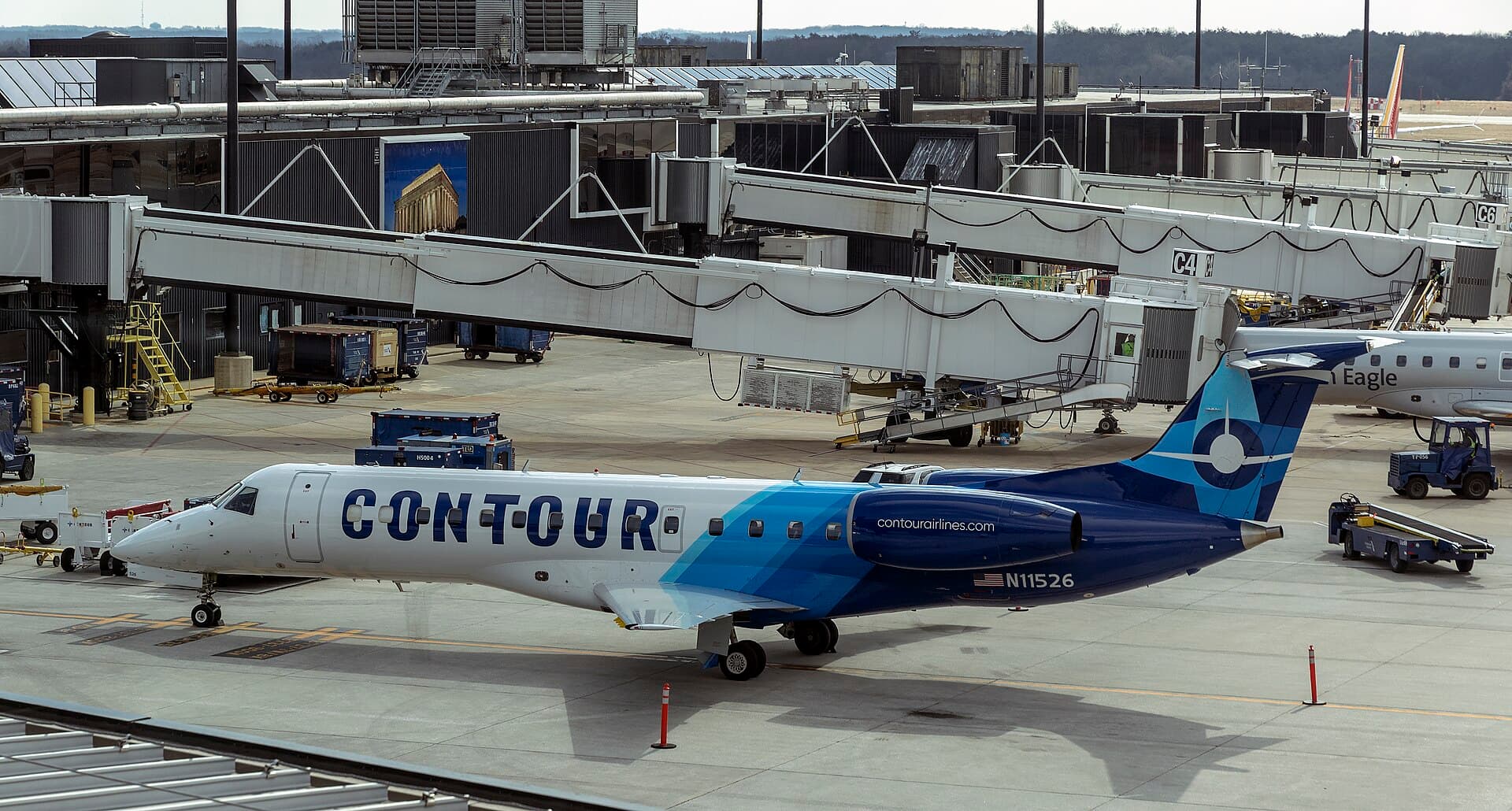 Embraer ERJ-135LR regional jet, registration N11526, in Contour Airlines' white and grey livery, parked on the apron at Baltimore-Washington International Airport in flat daylight, seen in profile with its rear-mounted engines and T-tail.