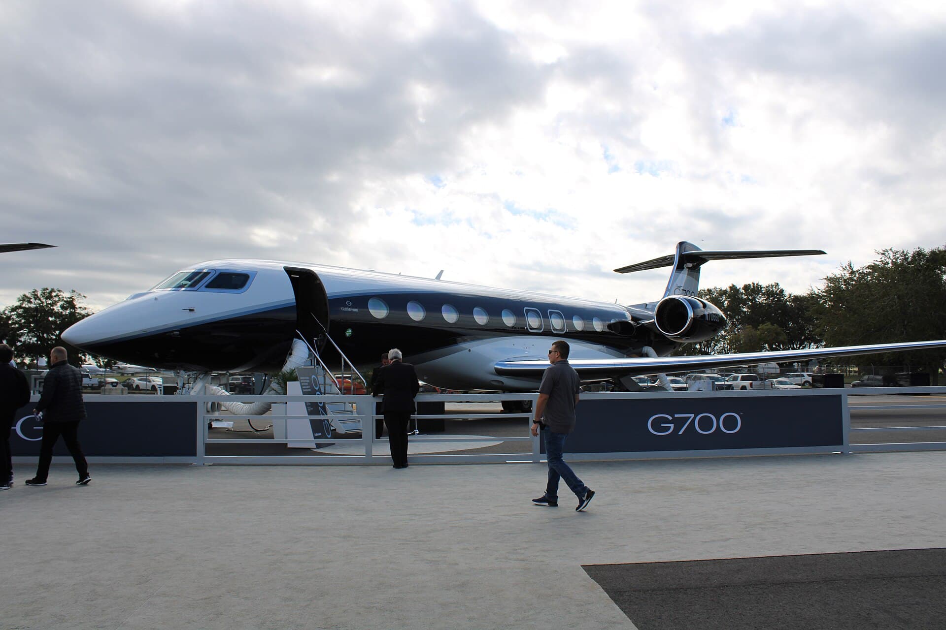 A Gulfstream G700 business jet registered N706GD parked in the manufacturer's white and blue house livery on the ramp at Orlando Executive Airport during the 2022 NBAA-BACE static display.