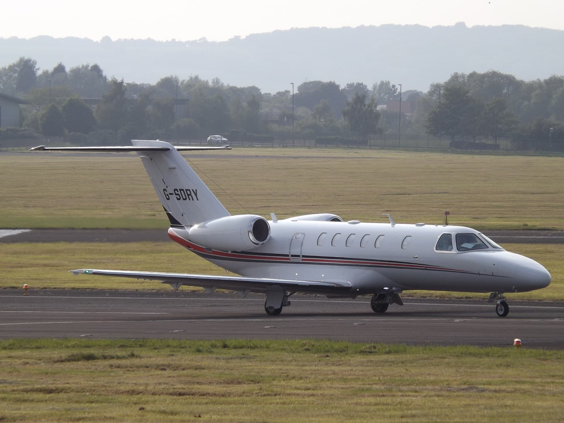 A Cessna Citation CJ4 light business jet, registration G-SDRY, on the ground at Gloucestershire Airport in late-afternoon light.