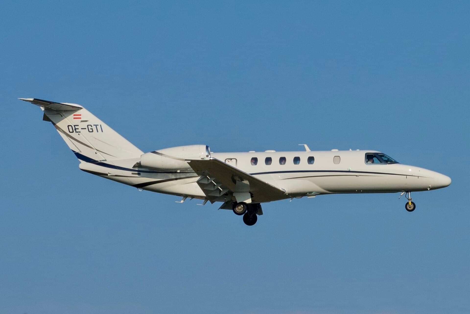 An Austrian-registered Cessna 525C Citation CJ4, OE-GTI, in a white corporate scheme on the ground at Geneva International Airport on a grey winter morning.