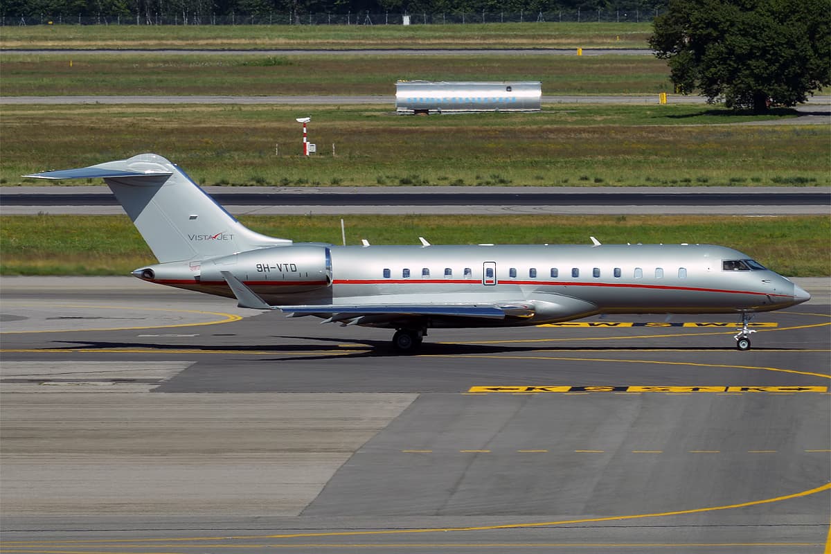 A Bombardier Global 5000 business jet registered 9H-VTD in VistaJet's silver livery with red tail markings, photographed at an airport in daylight.