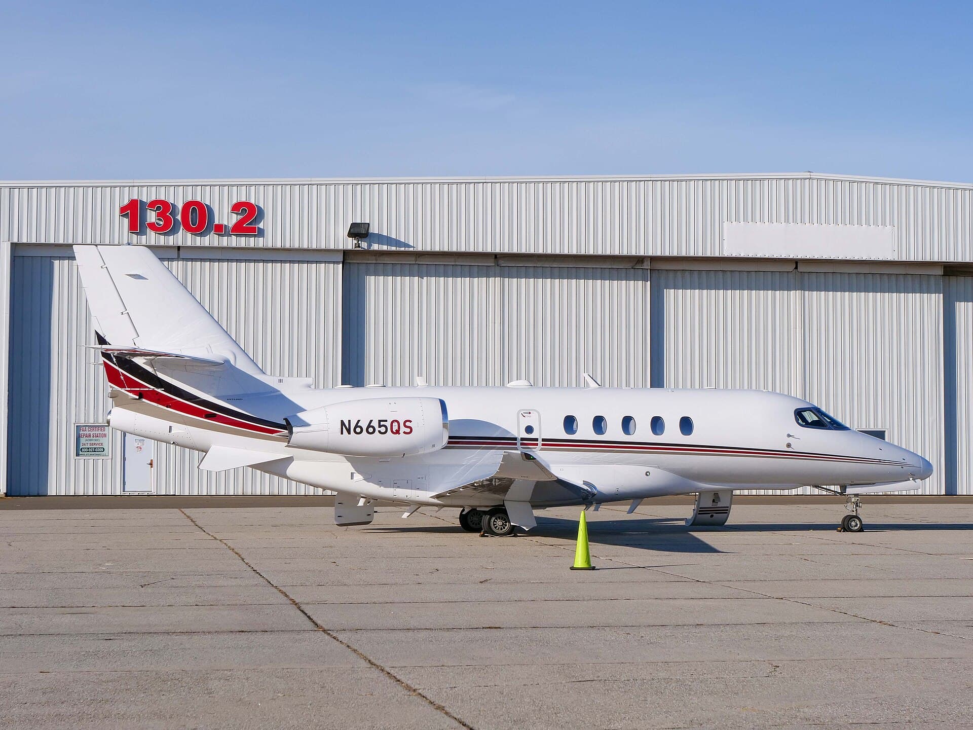 A Cessna Citation Latitude in NetJets' white and blue-grey livery, registration N665QS, photographed at Francis S. Gabreski Airport in Westhampton Beach, New York.